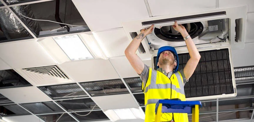 Técnico realizando manutenção preventiva em ar-condicionado cassete